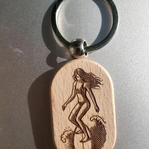 Wooden keychain with an engraved surfer girl design